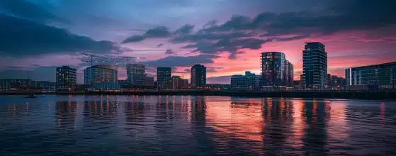 a dynamic urban skyline of cardiff at dusk, showcasing modern architectural designs and planning innovations, bathed in the warm glow of setting sun, reflecting the simplicity and clarity that jamatek brings to planning applications.