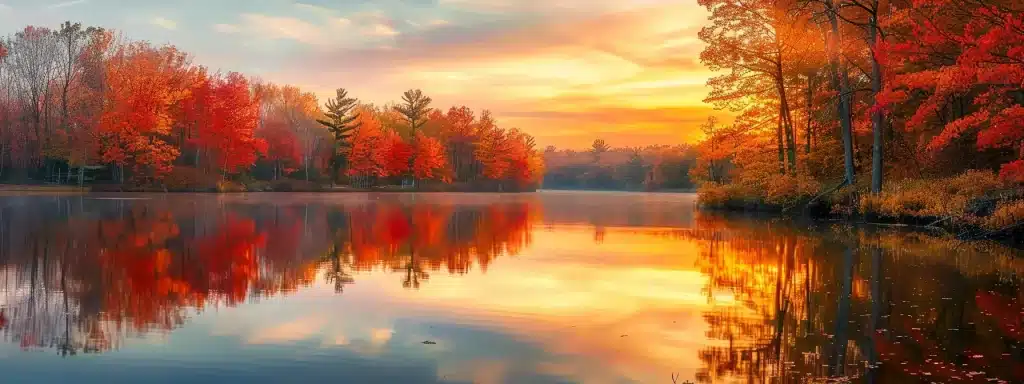 a vibrant autumn landscape unfolds with fiery-red maple trees reflecting in a serene lake, under a brilliant golden sunrise that casts a warm glow across the tranquil surroundings.