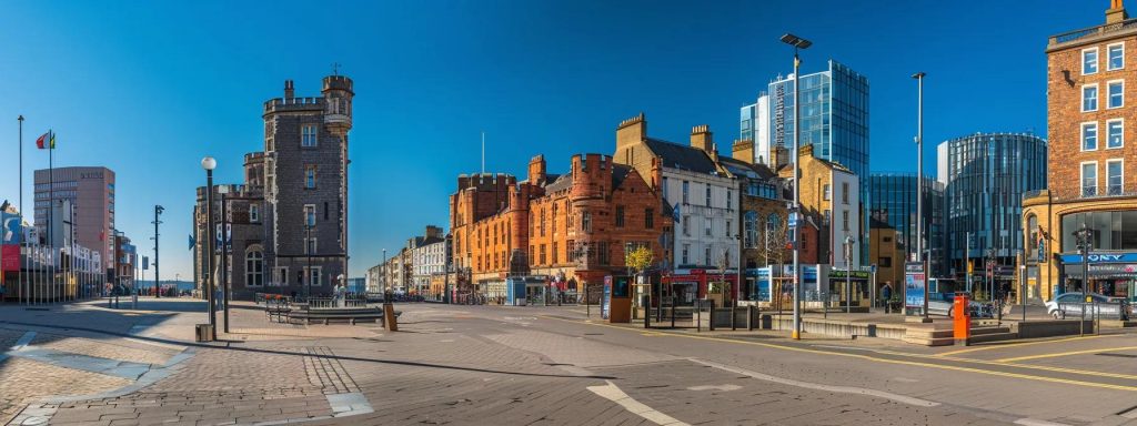 a vibrant urban landscape of cardiff's city centre showcases modern commercial towers and refurbished historic buildings, seamlessly integrating dynamic mixed-use spaces for retail, office, and residential functions under a clear blue sky.